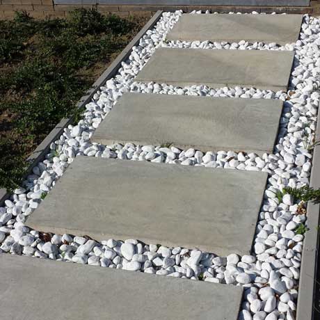 Een tuinpad met stapstenen in echte beton geborsteld